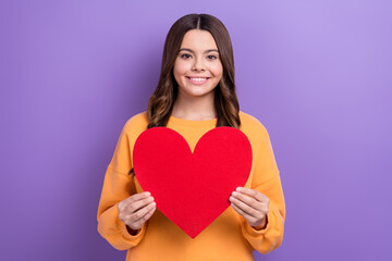 Sticker - Photo of cheerful friendly girl beaming smile hands hold paper red heart isolated on violet color background