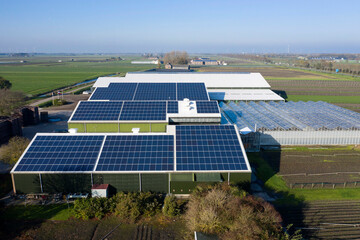 flower bulb company with solar panels in a row on a roof. photo taken with a drone. photovoltaic mod