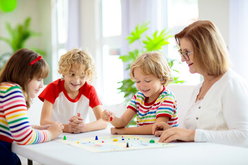 Wall Mural - Family playing board game. Kids play.