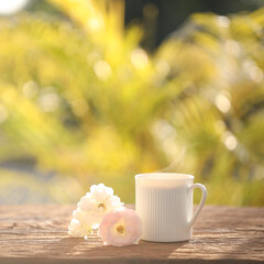 Wall Mural - White coffee mug and roses on wooden table outdoor