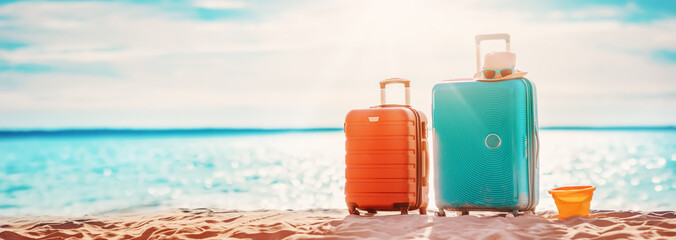 Panoramic view of the seacoast with suitcases on the sandbeach.