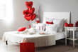 © Pixel-Shot - Interior of light bedroom decorated for Valentine's Day with breakfast and balloons