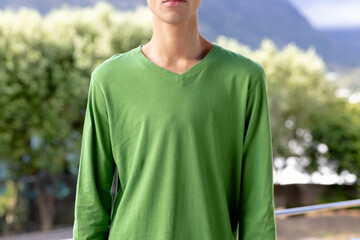 Image of biracial man in green long sleeve top with copyspace over trees in background