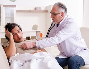 Wall Mural - Old male doctor visiting young male patient