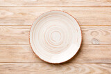 Fototapeta Kawa jest smaczna - Top view of empty colorful plate on wooden background. Empty space for your design