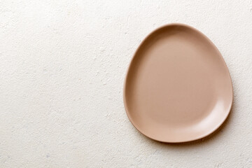 Top view of empty pink plate on cement background. Empty space for your design