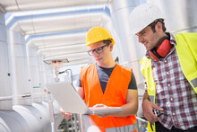 Engineer And Worker In Meeting With Laptop At Geothermal Power Station, Bavaria, Germany