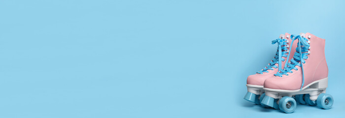 Wall Mural - pair of stylish quad roller skates on light blue background, space for text. banner design