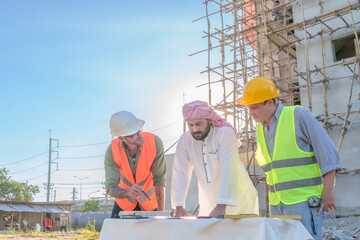 Wall Mural - Diverse team of professionals using tablet computers on construction site. Real estate construction project. with civil engineers, architects, Arabic business investors and explorer with theodolite