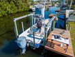 © christian.bitzas - Tower boat with covers on boat lift with deck dock with person on board in Tampa Florida from aerial drone