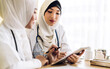 © Art_Photo - Professional medical two muslim asian woman doctor team with stethoscope in uniform working and look at tablet in hospital.healthcare and medicine