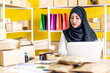 © Art_Photo - Muslim asian woman freelancer sme business online shopping working and checklist order with cardboard box on table at home - Business online shipping and delivery concept