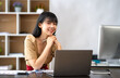 © crizzystudio - Asian Businesswoman working on laptop at her desk at the office.