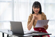 © crizzystudio - Asian Businesswoman working on laptop at her desk at the office.