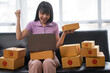 © crizzystudio - Asian women working SME business at the workplace at home. use laptop to check customer orders online shipping boxes, freelance SME entrepreneur online business idea.