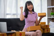 © crizzystudio - Asian women working SME business at the workplace at home. use laptop to check customer orders online shipping boxes, freelance SME entrepreneur online business idea.
