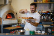 © zorandim75 - Male chef is sprinkling fresh oregano over a traditionally made home pizza.