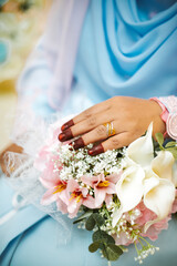 Wall Mural - Young girl in a blue wedding dress holds in her hands a bouquet of flowers.