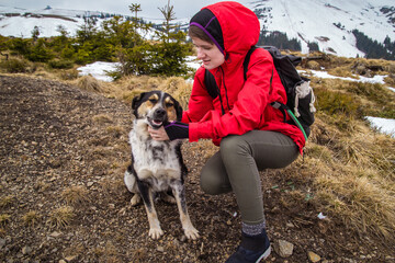 Poster - Woman scratching dog at highland scenic photography. Picture of person with distant mountains on background. High quality wallpaper. Photo concept for ads, travel blog, magazine, article