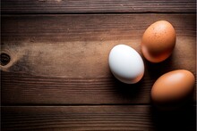  Three Eggs Are Sitting On A Wooden Surface Together, One Is Brown And One Is White And The Other Is White And Brown And Has A Brown Spot On The Side Of The Egg Shell.