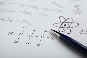 Wall Mural - Sheet of paper with different chemical formulas and pen, closeup