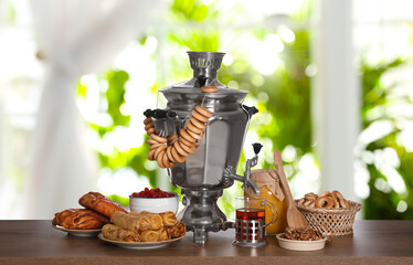 Wall Mural - Traditional Russian samovar and treats on wooden table against window in room