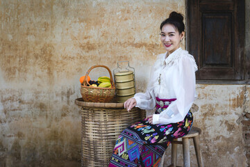 Wall Mural - Tourist an Asian Thai woman dressed in traditional Thai dress at the old house in Lampang, Thailand. Retro fashion style concept.