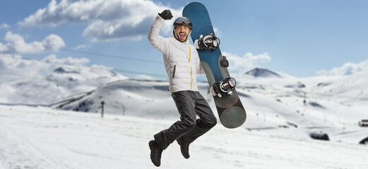 Sticker - Happy man with a snowboard jumping and gesturing happiness on a mountain