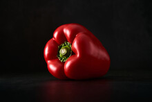 Red Bell Pepper Isolated Against A Black Background. Vegetables Artfully Presented. Close Up Of A Nutritious Paprika.