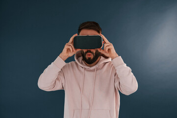 Wall Mural - In VR glasses. Handsome man is in the studio against blue background