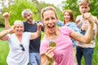 © Robert Kneschke - Successful woman with a medal cheers in front of the team