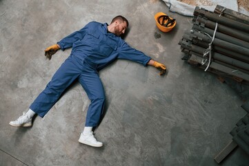 Wall Mural - Top view of dead factory worker that lying on the ground. Conception of safety, bad accident