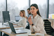 © standret - Woman is sitting by a table with laptop. Successful team are working together in the office. Conception of business