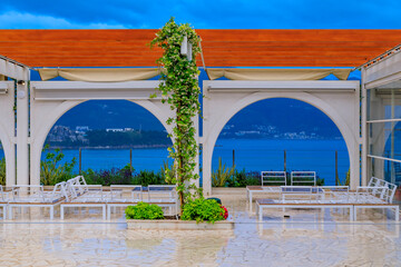 Poster - Outdoor al fresco seating in a restaurant in Budva with the view of the Old Town and the Adriatic Sea in Montenegro at sunset