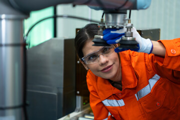 In an electronic parts facility, Female engineers In the plant, inspecting and testing robotic hands used in the production of electronic components.