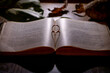 An old open book with a gold ring dropping a shadow in a form of a heart
