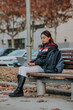 © ADDICTIVE STOCK - Concentrated woman browsing laptop on bench