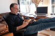 © ADDICTIVE STOCK - Mature happy man resting with tablet in home office