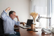 © ADDICTIVE STOCK - Man making triumph gesture while using netbook