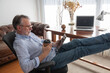 © ADDICTIVE STOCK - Mature man resting with tablet in home office
