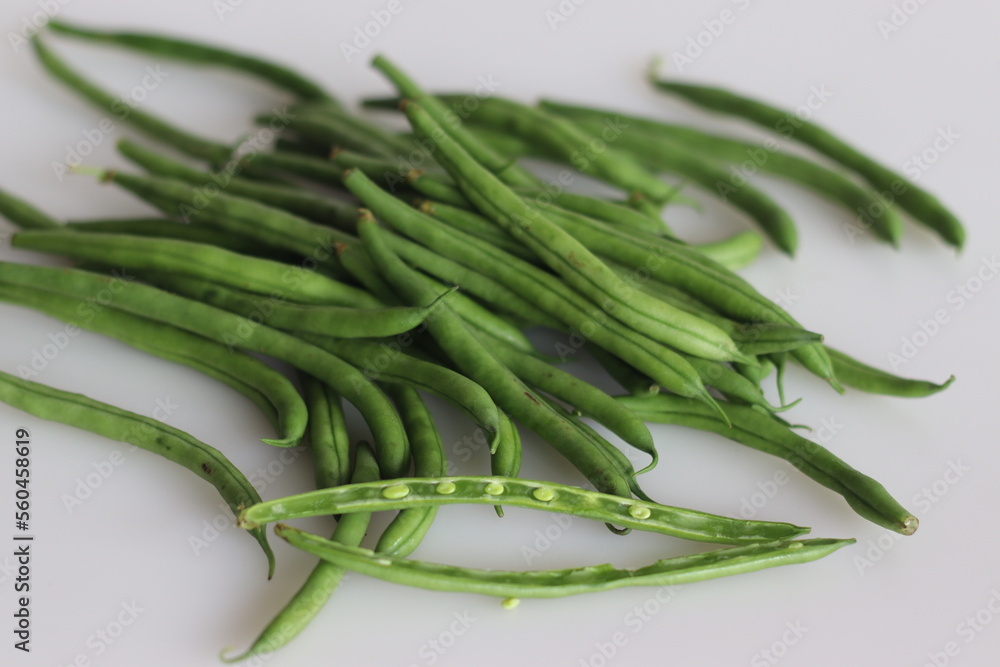 Bunch of French Beans shot on white back ground with few sliced half ...