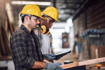 Young adult men carpenter craftman working in small business wood workshop. Timber industry and furniture industry.