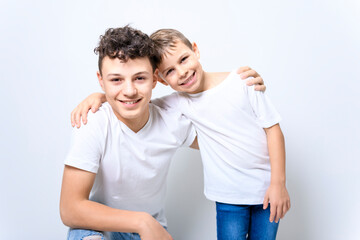 portrait of handsome brother posing near the white wall