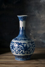 Old White Porcelain Vase With A Blue Pattern Against A Gray Wall