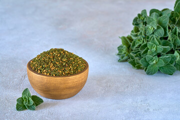 Wall Mural - Mixed spice zaatar or zatar in wooden bowl with fresh zaatar leaves