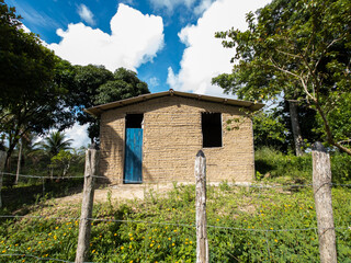 Canvas Print - isolated mud house in rural farm on sunny day with blue sky