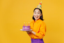 Side View Happy Fun Smiling Young Woman Wear Casual Clothes Cap Hat Celebrating Holding Purple Cake With Candles Look Camera Isolated On Plain Yellow Background. Birthday 8 14 Holiday Party Concept
