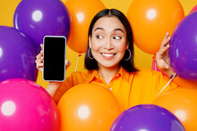 Close Up Fun Young Woman Wearing Casual Clothes Celebrating In Bunch Of Balloons Use Mobile Cell Phone With Blank Screen Area Isolated On Plain Yellow Background. Birthday 8 14 Holiday Party Concept.