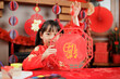 young girl with traditional dressing up celebrating Chinese new year against all kind of 