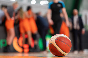 Wall Mural - the ball lying on the parquet and the basketball team in the background.